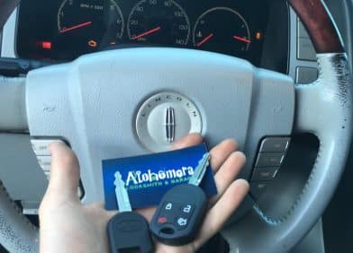 Inside a BMW with keys being held up to the steering wheel | Alohomora Locksmith Services All BMW Makes and Models in Portland OR